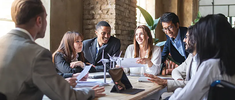 A diverse team of employees meeting at their conference table.