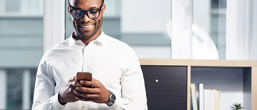 A well dressed individual using their mobile device.