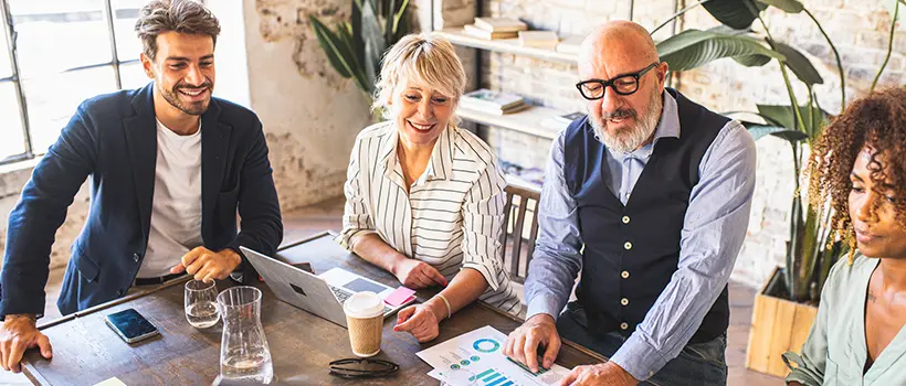 A multigenerational team of employees reviewing data.